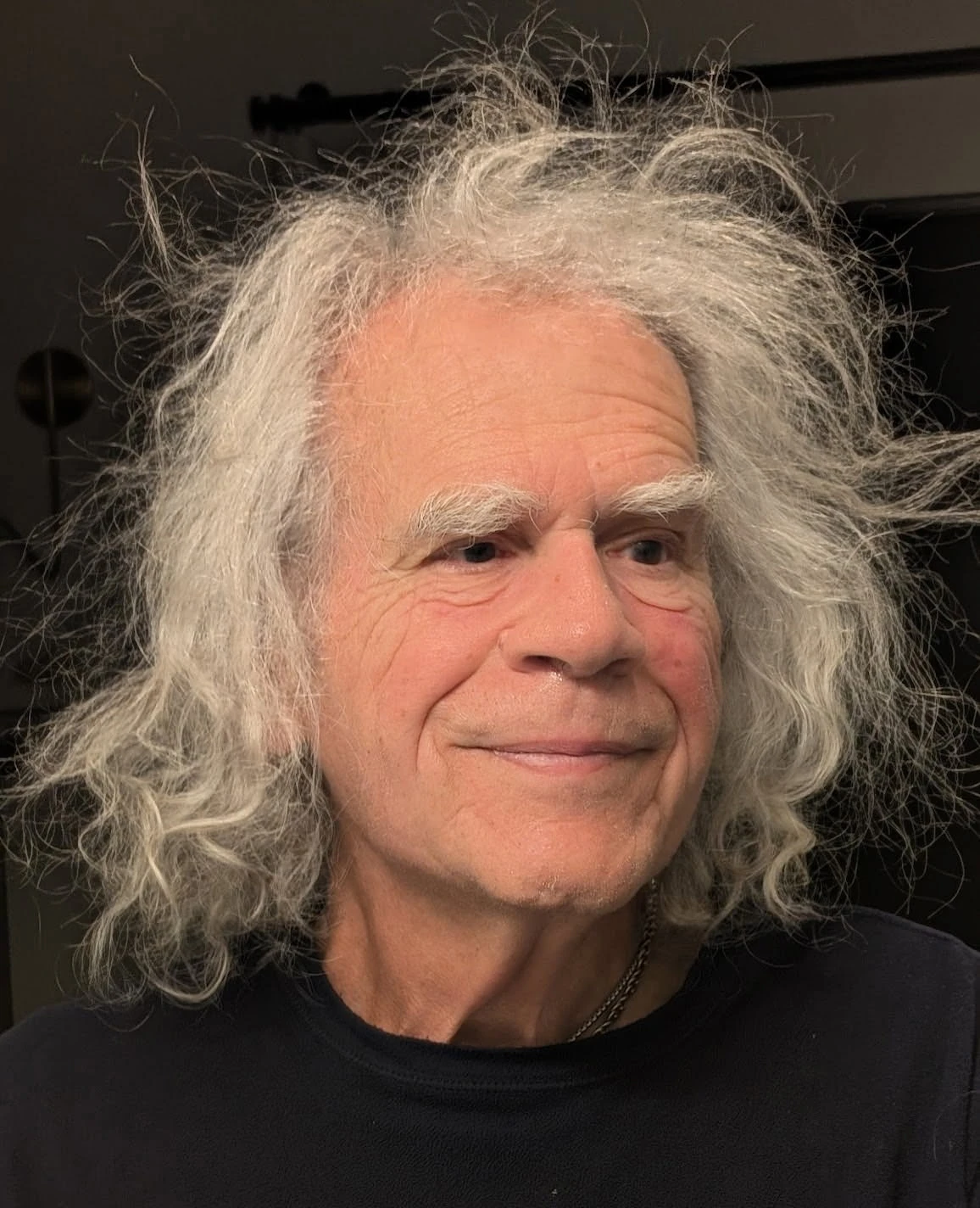 Mike Wolf at 83: white hair going in every direction, half a smile.